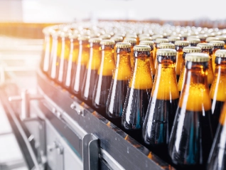 filled bottles lined up at a factory