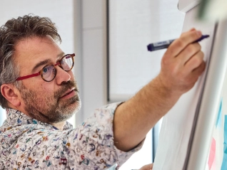 Atradius Man making notes on a flipchart at a workshop