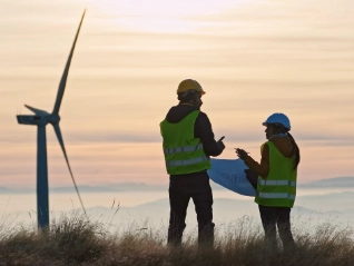 Two wind turbine engineers at sunset