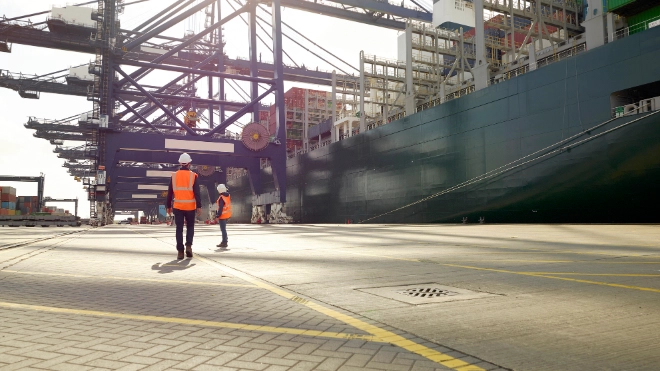 Dock workers beside cargo ship at Port of Felixstowe, England
