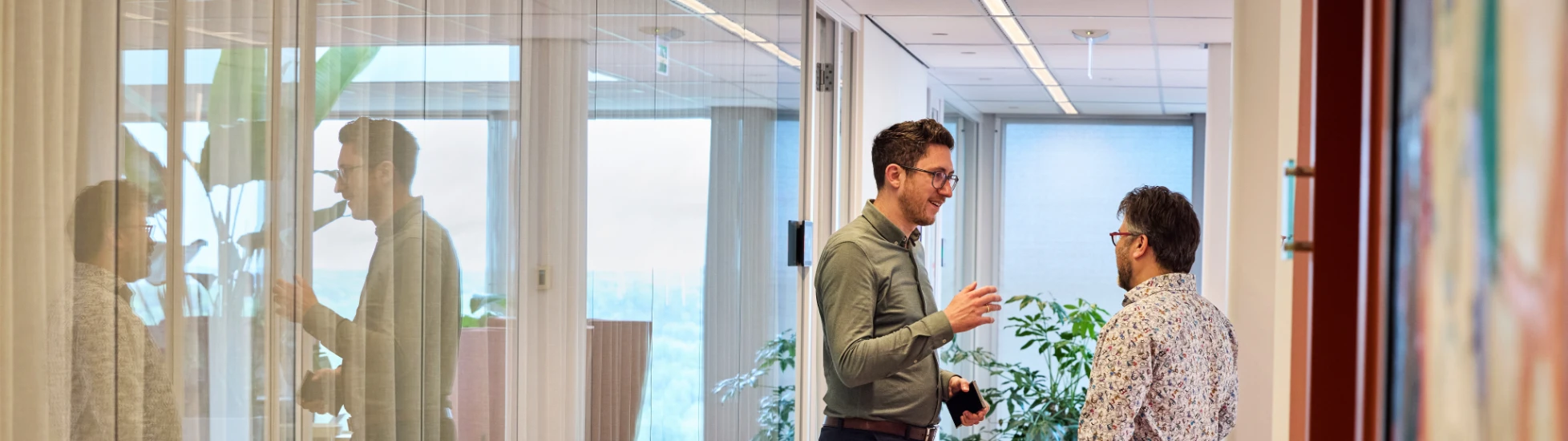 Two colleagues confer briefly in the corridor