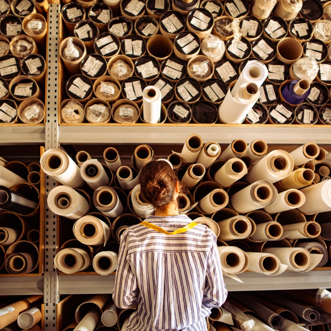 Female textile worker examining reels of fabric