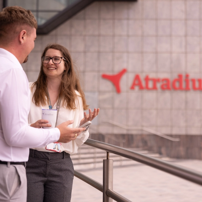 Woman and man have coffee break outside at the entrance of the Cardiff office Woman and man have coffee break outside at the entrance of the Cardiff office